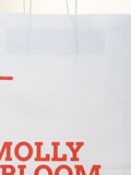 photographie du sac avec le logotype de la librairie et l'adresse du site web, imprimé en flexographie, Pantone Warm Red sur kraft